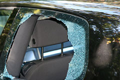 back window glass of black sedan is broken from thief smashed it in